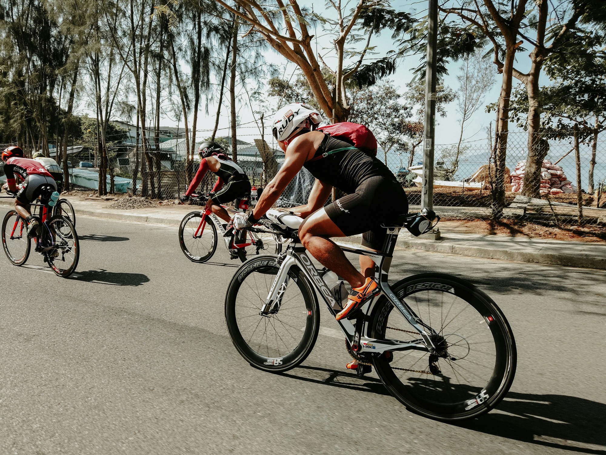 Triathletes on time-trial bikes on a coastal road